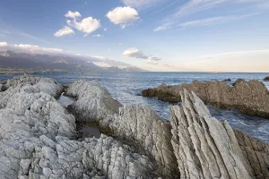 Rocky coast on the Kaikoura Peninsula, mountains of the Kaikoura Range in the background, Kaikoura, Canterbury, South Island, New Zealand, Oceania