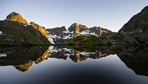 Rocky mountain peaks reflected in a small pond