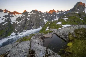 Rocky mountain peaks and Trollfjordvatnet with snow