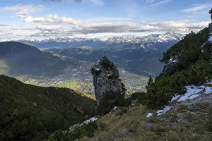 Rocky peak with summit cross, view of Garmisch-Partenkirchen and mountain panorama