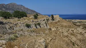 Rocky ruins on a coastal landscape with sea and sunny sky
