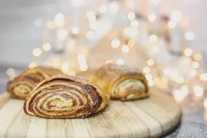 Rolled pastries on a wooden board against a bokeh light backdrop