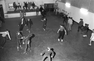 Roller skate fun in the 1960s. Interior of a roller disco with people roller skating