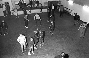 Roller skate fun in the 1960s. Interior of a roller disco with people roller skating. Roller skating began to trend at this time and throughout the 1970s when roller skating was associated with disco music and roller discos