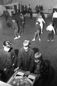 Roller skate fun in the 1960s. Interior of a roller disco with people roller skating