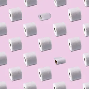Rolls of white toilet paper on a pink background