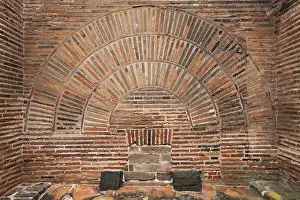 Roman wall with brick round arch above a sewer