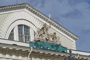 Roof of a historic building with Poseidon sculptures against a cloudy sky
