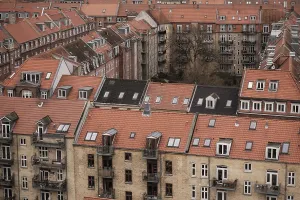Rooftop view of densely packed residential buildings with red tile roofs under an overcast sky in Aarhus