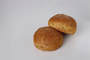 Two round buns made from whole wheat flour on a white background