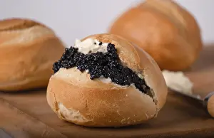 Framed Print : One round wheat bun with butter and black caviar