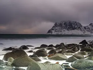 Rounded rocks on Utakleiv beach in a dramatic cloudy atmosphere