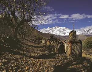 Row of ancient Buddhist devotional objects or chortens with the northern part of the Dhaulagiri Himal behind near