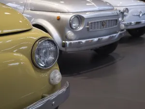Row of classic cars with yellow and silver vehicle in the foreground