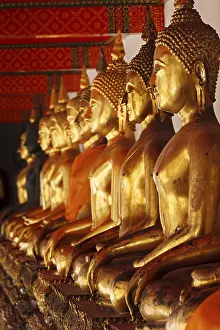 Row of sitting Buddha statues in Buddhist temple Wat Pho