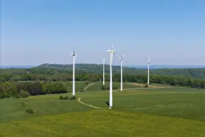Row of wind generators on an undulating landscape with clear sky