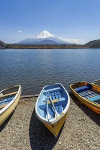 Rowing boats on the shore, view over the lake to the volcano Mt Fuji