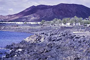 Framed Print : Rugged coastal area with rocks and views of reddish brown mountains under cloudy sky Framed Print : Rugged coastal area with rocks and views of reddish brown mountains under cloudy sky