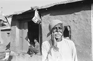 Rural man standing outside of his house