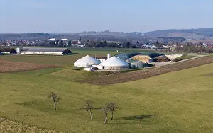 Rural scene with biogas plant, few trees and village