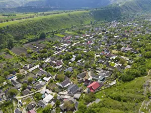 Rural village nestled in a green landscape with hilly environments