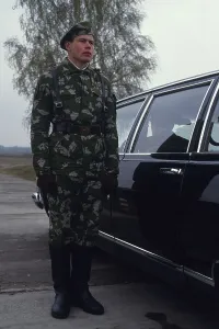 Russian soldier standing beside a car