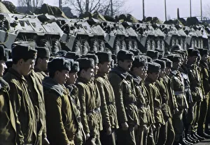 Russian soldiers standing in front a train transporting armoured vehicles during the withdrawal of Soviet troops