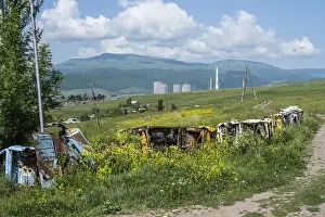 Framed Print : Rusty vehicles stand in a meadow in front of a wooded mountain panorama Framed Print : Rusty vehicles stand in a meadow in front of a wooded mountain panorama