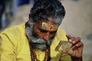 Sadhu, saint, looking in mirror
