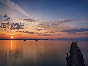 Sailing boats and jetty on Lake Chiemsee at sunrise