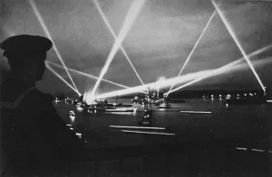 Sailing, on the evening of the final day play of the searchlights from the ships of the Kriegsmarine in Kiel harbour