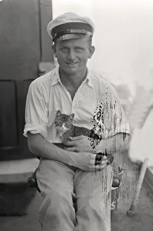 Sailor with cat in his arms on board a cargo ship
