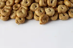 Salty tarallini cookies scattered on a white background