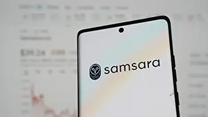Samsara logo on a smartphone with pastel hues and financial chart in the background