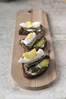 Sandwiches with sardines on a long wooden board