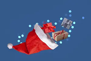 Santa Claus hat and gifts on blue background