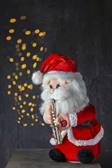 Santa is playing saxophone new year's party on a dark background bokeh<br> Santa is playing saxophone new year's party