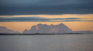 Sea and rocky mountain peaks, at sunset