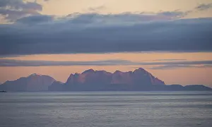 Sea and rocky mountain range, at sunset