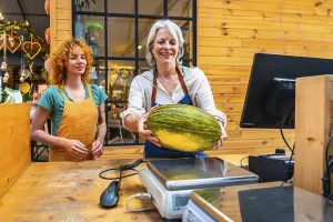 Senior greengrocer carefully weighing a fresh