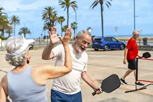 Senior man and woman exchanging a high five
