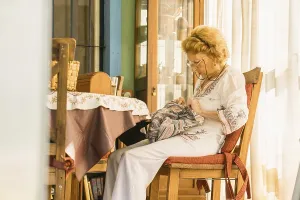Senior woman enjoying her retirement sewing a colorful bag
