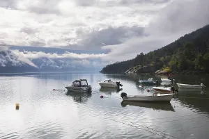 A serene lake in Norway reflects moored boats