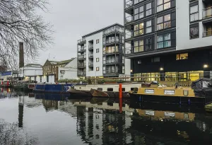 A serene London canal scene showcasing modern apartments alongside moored boats