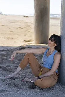 Serene moment of a woman enjoying a quiet Zen break under a coastal bridge