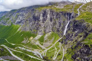The serpentine road meanders on the green slopes of the canyon