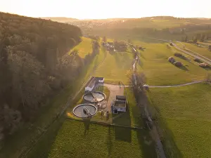 Sewage treatment plant between green fields and a forest
