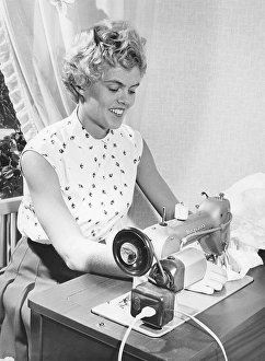 Sewing in the 1950s. Swedish female athlete and high-jump champion Inga-Britt Lorentzon at her sewing machine, a swedish model from manufacturer Husqvarna
