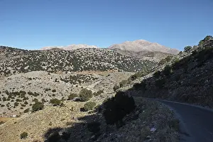 Shaded mountain road, sparse vegetation