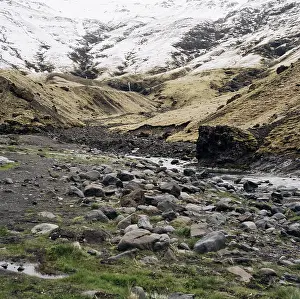 Shallow little mountain river, flows from snow-capped mountains into the gorge